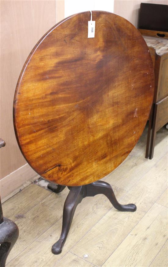 A George III mahogany circular tilt top table on pillar and tripod base, Diameter 84cm, H.71cm